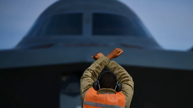 A U.S. Air Force crew chief lines up a B-2 Spirit stealth strategic bomber